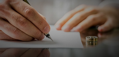 man signing papers for divorce with wedding band